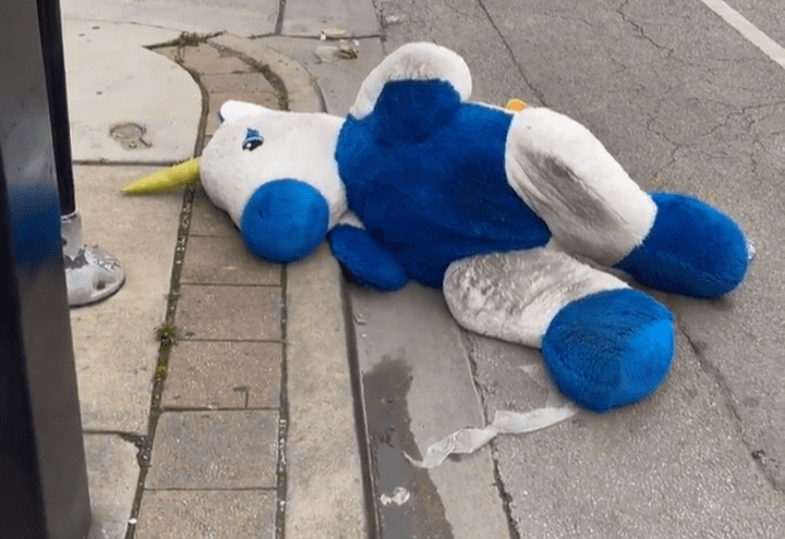 A blue color unicorn lying on the road